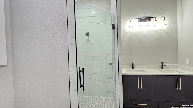 bathroom featuring a shower with door and vanity