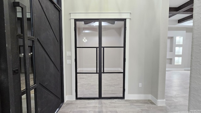 entryway with beam ceiling, light hardwood / wood-style floors, and coffered ceiling