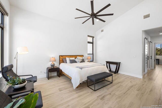 bedroom featuring high vaulted ceiling, light hardwood / wood-style floors, and ceiling fan