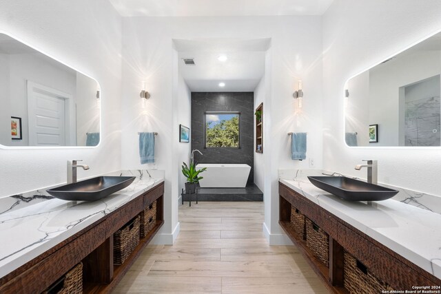 bathroom with vanity, hardwood / wood-style flooring, and a bathing tub