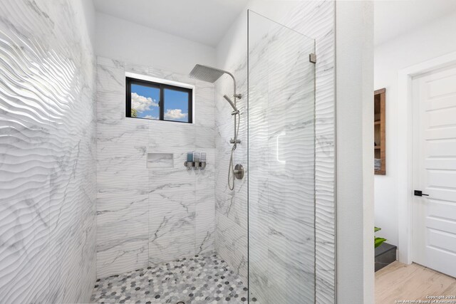 bathroom with hardwood / wood-style floors and tiled shower