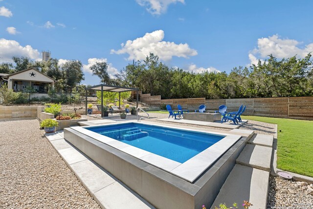 view of swimming pool featuring a jacuzzi, an outdoor fire pit, a lawn, and a patio area