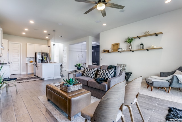 living room featuring light wood-type flooring and ceiling fan