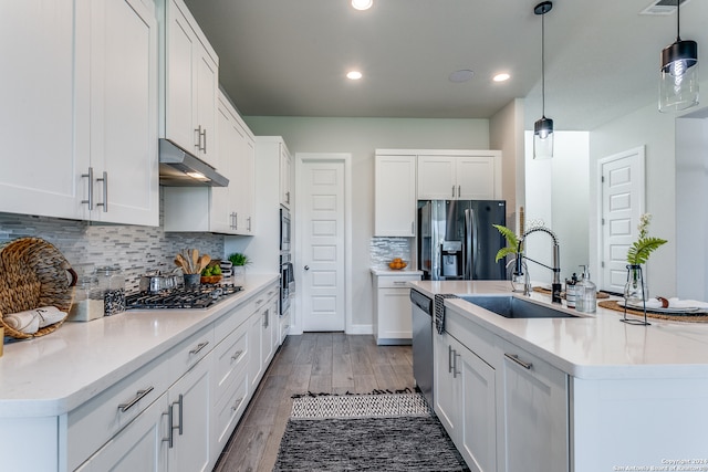 kitchen with appliances with stainless steel finishes, decorative light fixtures, and white cabinets