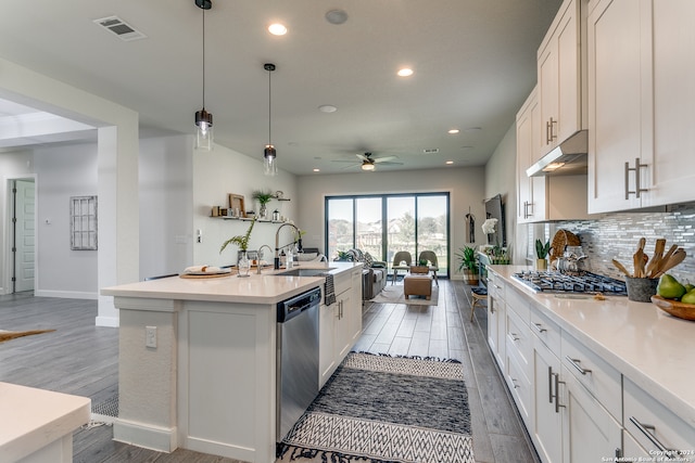 kitchen with stainless steel appliances, white cabinetry, an island with sink, hardwood / wood-style floors, and pendant lighting