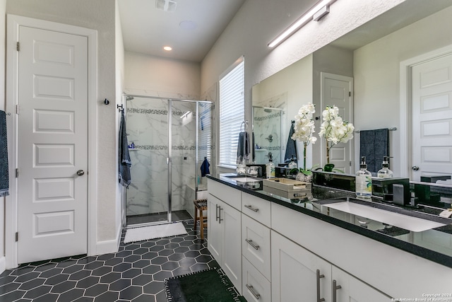 bathroom featuring vanity, tile patterned flooring, and a shower with door