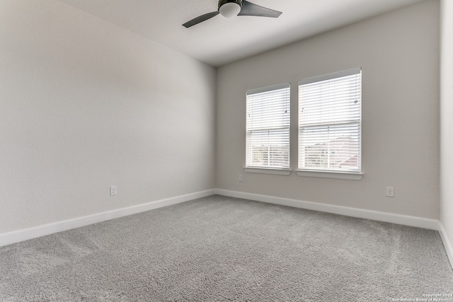 carpeted spare room with ceiling fan