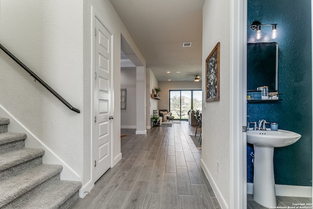 hallway with wood-type flooring and sink