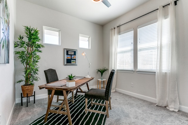 carpeted dining area with ceiling fan