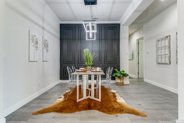 dining space with wood-type flooring and crown molding