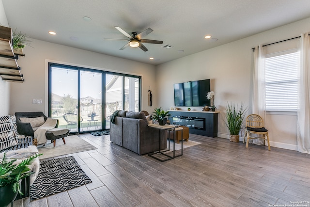 living room featuring wood-type flooring and ceiling fan