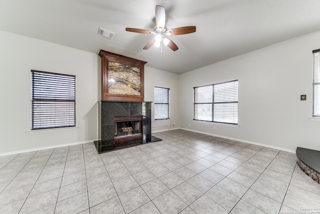 unfurnished living room featuring light tile patterned floors, a high end fireplace, and ceiling fan