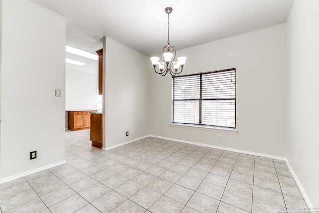 tiled empty room featuring a notable chandelier