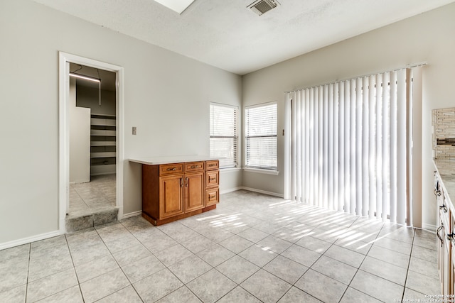 interior space featuring a textured ceiling and light tile patterned floors