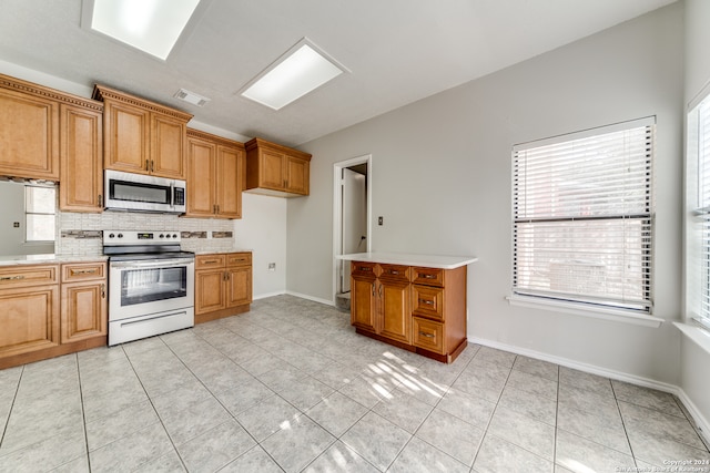 kitchen with range with electric stovetop, light tile patterned floors, and tasteful backsplash