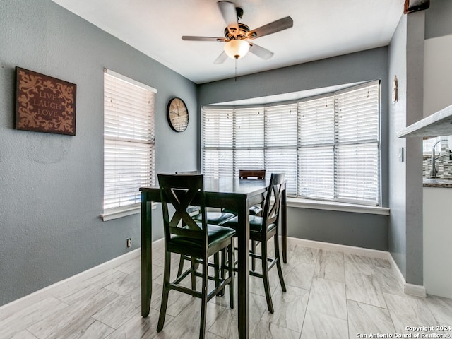 dining area with ceiling fan and sink