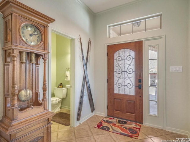 foyer entrance featuring light tile patterned floors and ornamental molding