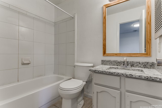 full bathroom featuring tiled shower / bath, a textured ceiling, and vanity