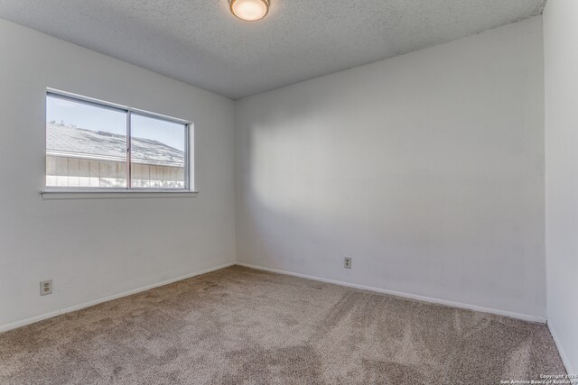 carpeted spare room featuring a textured ceiling