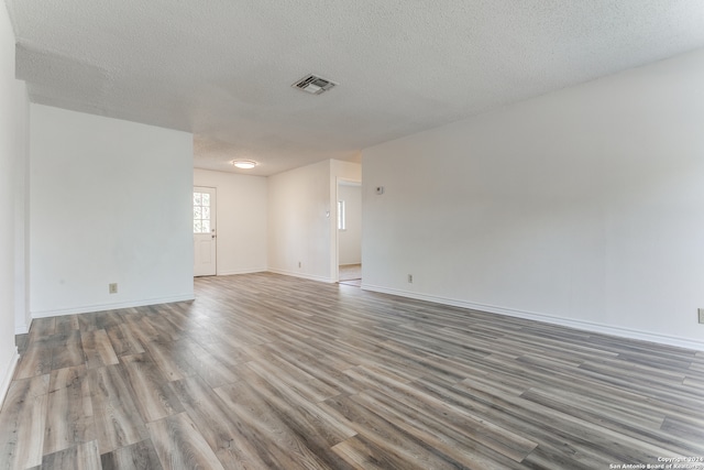 empty room featuring a textured ceiling and hardwood / wood-style flooring