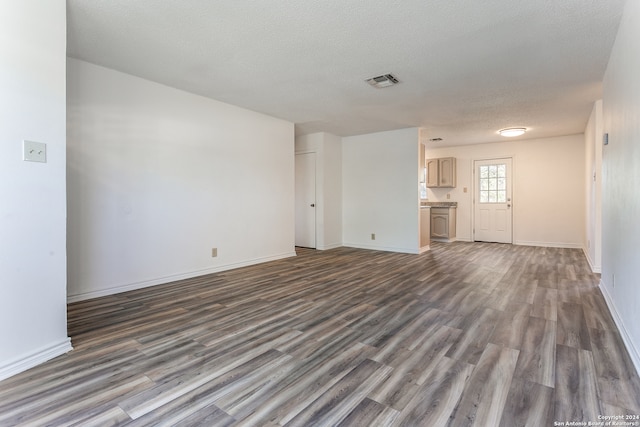 unfurnished living room with dark hardwood / wood-style floors and a textured ceiling