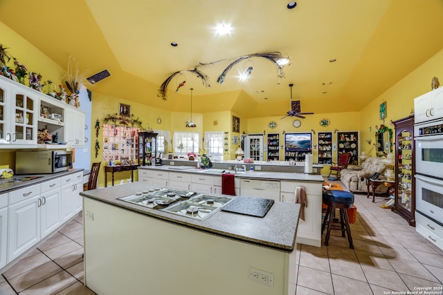 kitchen featuring white cabinetry, kitchen peninsula, ceiling fan, stainless steel appliances, and a kitchen island