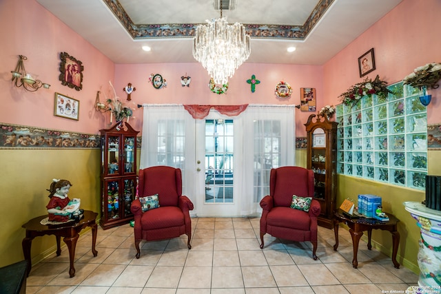 sitting room featuring french doors, a tray ceiling, a notable chandelier, and light tile patterned flooring