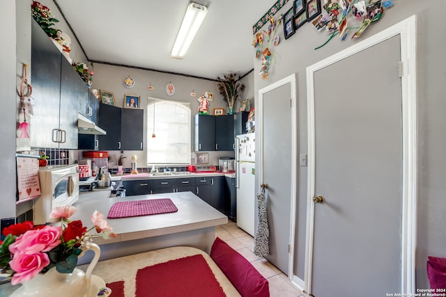 kitchen featuring kitchen peninsula, sink, light tile patterned flooring, and white fridge