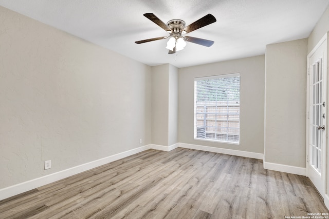 spare room with ceiling fan, light wood-type flooring, and french doors