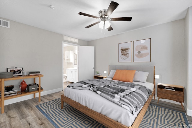 bedroom featuring ensuite bath, wood-type flooring, and ceiling fan