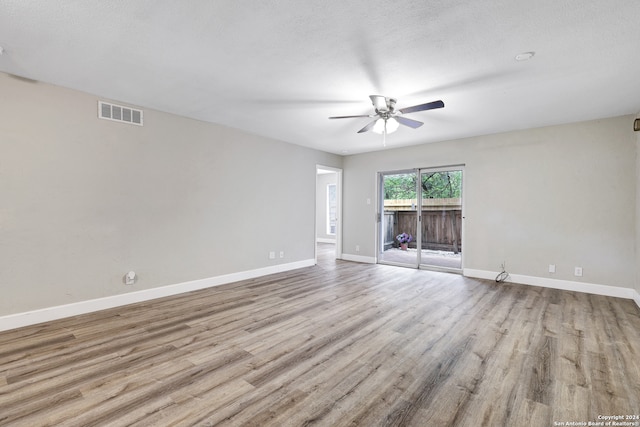 empty room with light hardwood / wood-style floors, ceiling fan, and a textured ceiling