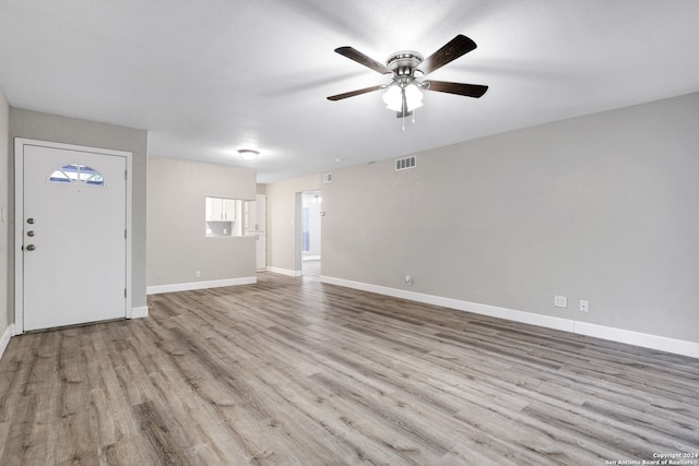 unfurnished living room featuring a textured ceiling, ceiling fan, and light hardwood / wood-style flooring