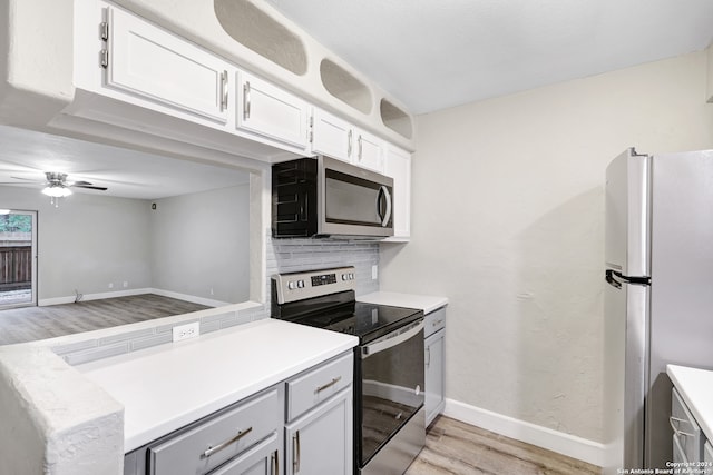 kitchen with white cabinetry, appliances with stainless steel finishes, tasteful backsplash, ceiling fan, and light wood-type flooring