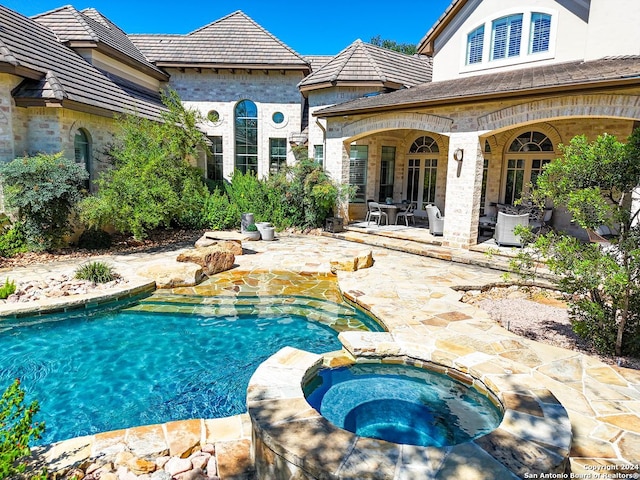 view of pool featuring an in ground hot tub and a patio area