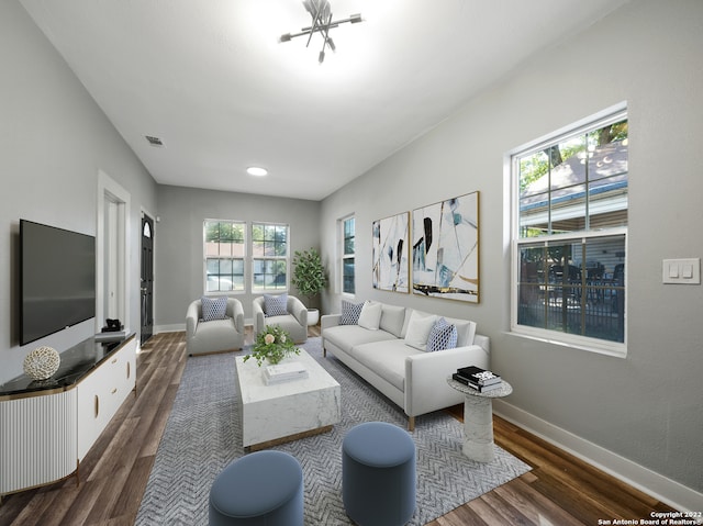 living room with dark wood-type flooring and an inviting chandelier