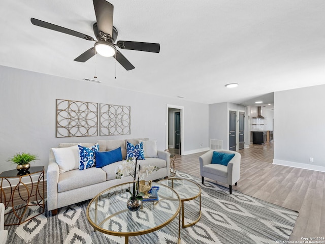 living room featuring light wood-type flooring and ceiling fan