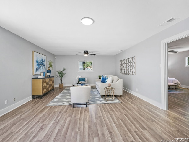 living room with ceiling fan and light hardwood / wood-style flooring