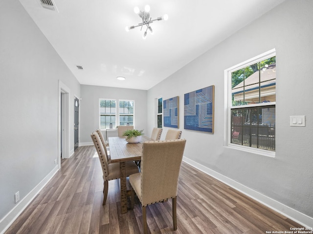 dining room with wood-type flooring and an inviting chandelier