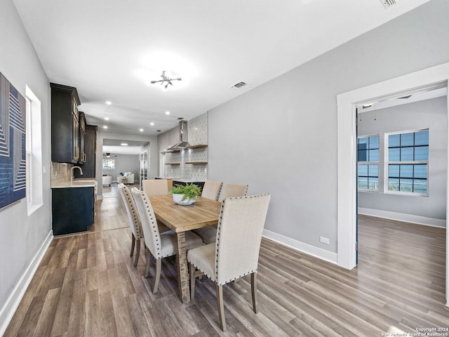 dining space featuring sink, an inviting chandelier, and dark hardwood / wood-style flooring