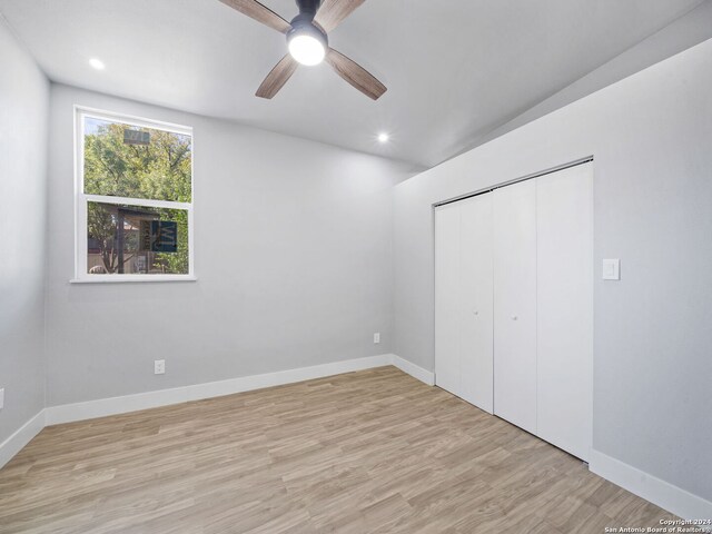 unfurnished bedroom featuring a closet, light hardwood / wood-style floors, and ceiling fan