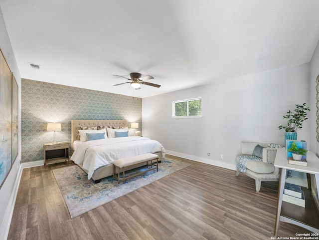 207 Ray Ave, San Antonio, TX 78204 - bedroom featuring wallpapered walls, an accent wall, wood finished floors, and a ceiling fan