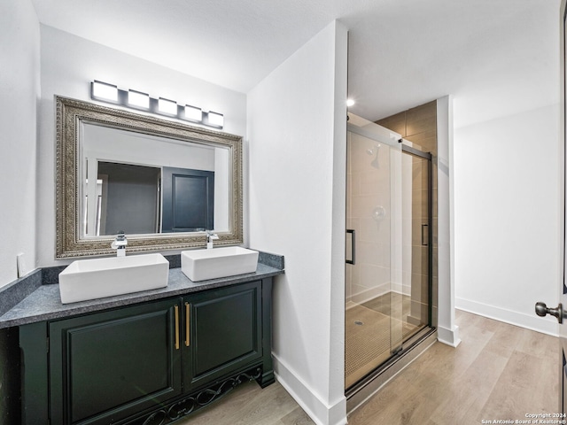 bathroom with hardwood / wood-style flooring, vanity, and an enclosed shower