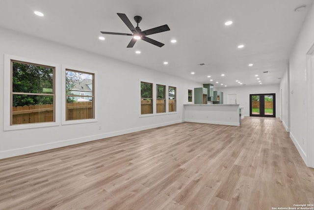 unfurnished living room with light wood-type flooring, french doors, and ceiling fan