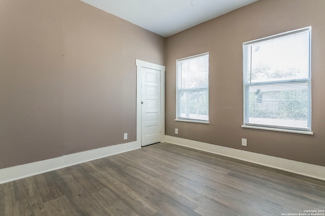 spare room featuring dark hardwood / wood-style floors and a healthy amount of sunlight