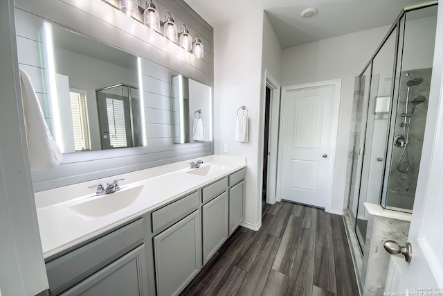 bathroom featuring hardwood / wood-style floors, a shower with shower door, and vanity