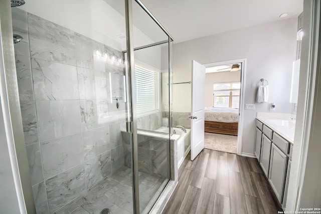 bathroom with walk in shower, vanity, hardwood / wood-style flooring, and ceiling fan