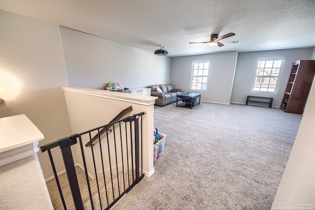 interior space with a textured ceiling and ceiling fan