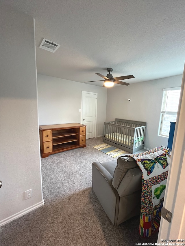 carpeted bedroom featuring a textured ceiling and ceiling fan