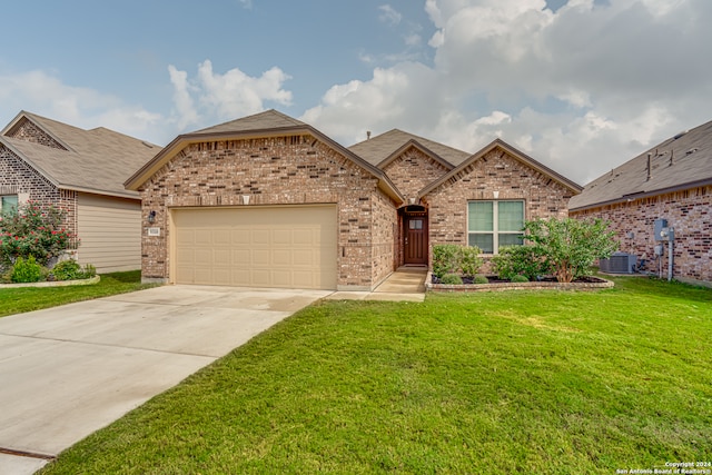 view of front of home with a garage, cooling unit, and a front lawn