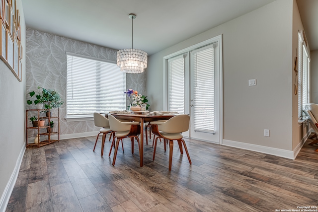 dining space featuring wood-type flooring and a notable chandelier